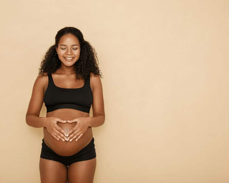 Une femme enceinte, posant les mains sur son ventre